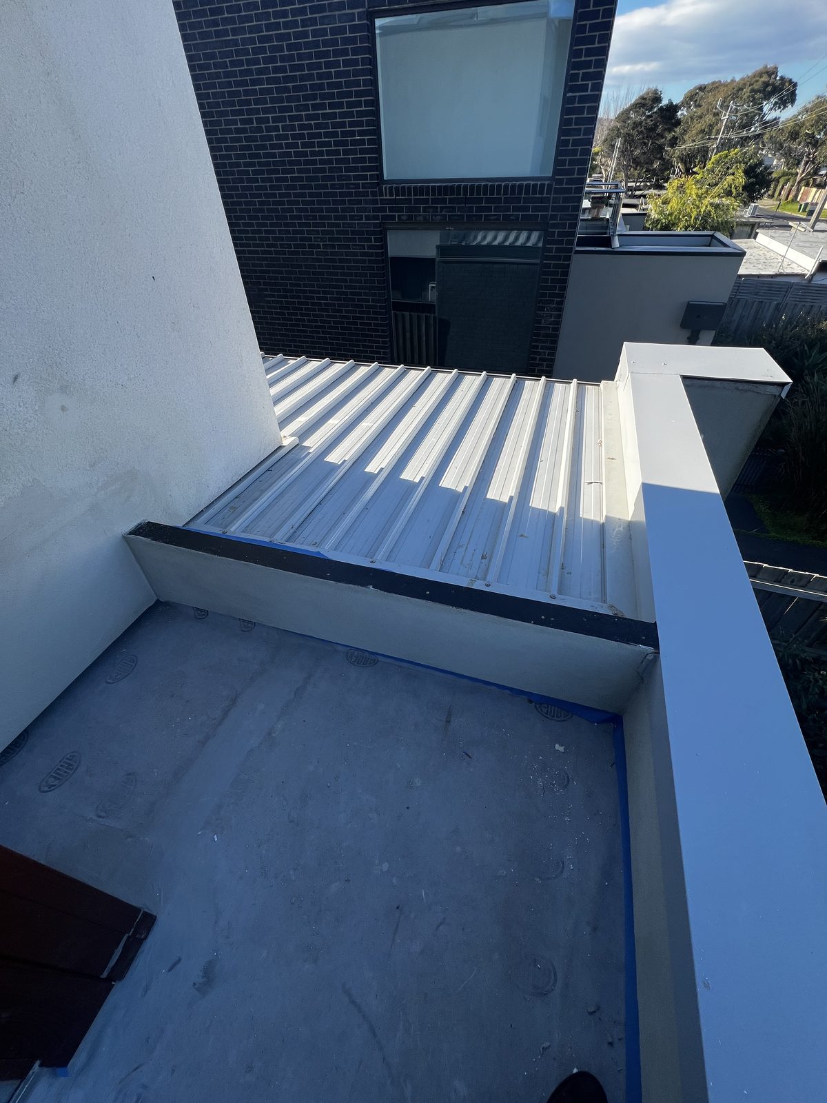 A balcony deck masked at the wall junctions and upstand, with the waterproofing membrane applied, Mornington Peninsula.