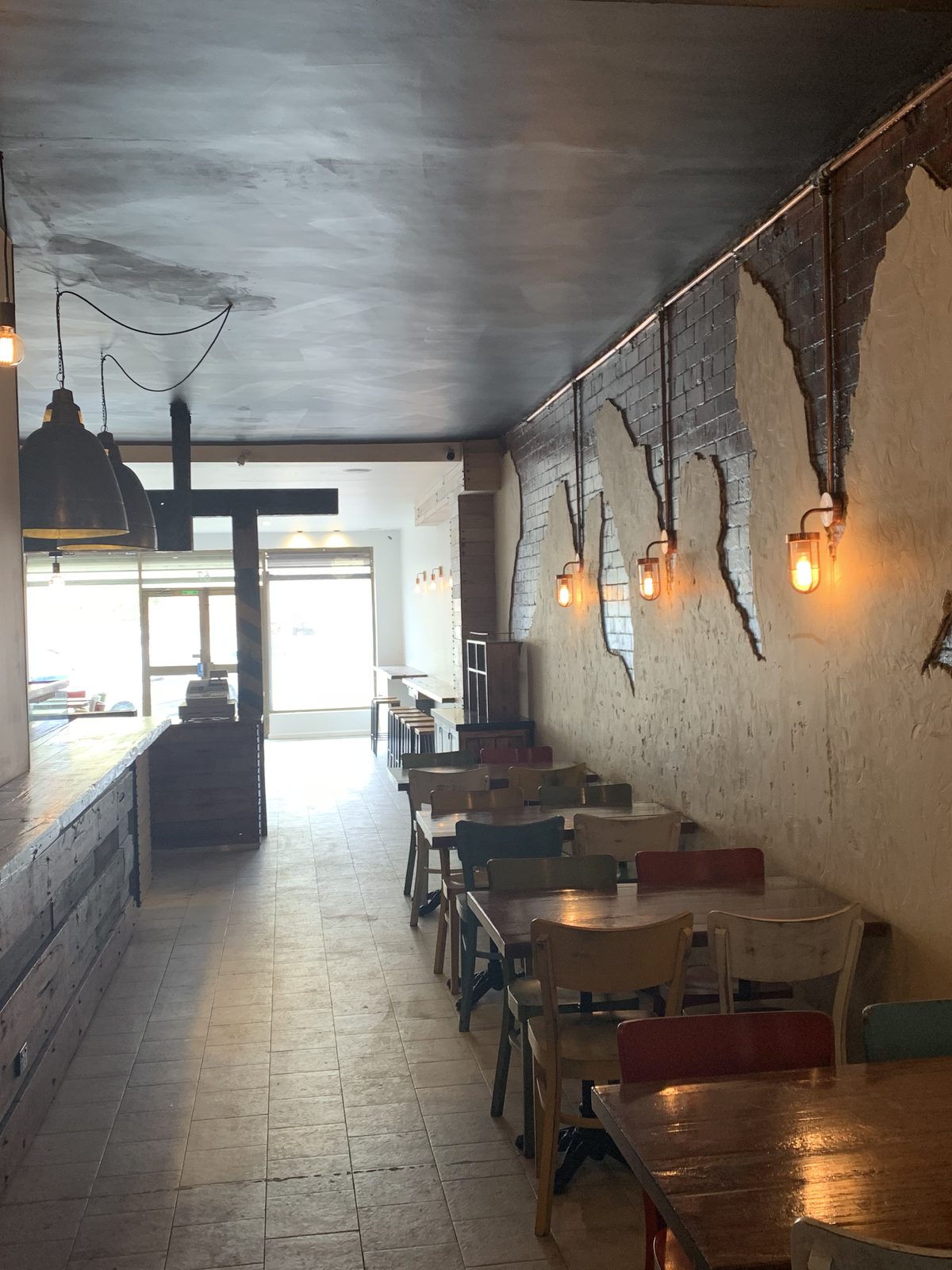 Narrow restaurant dining room looking to the shopfront, with timber tables, exposed brick and a recycled timber counter, Coal Workshop, Melbourne’s west.