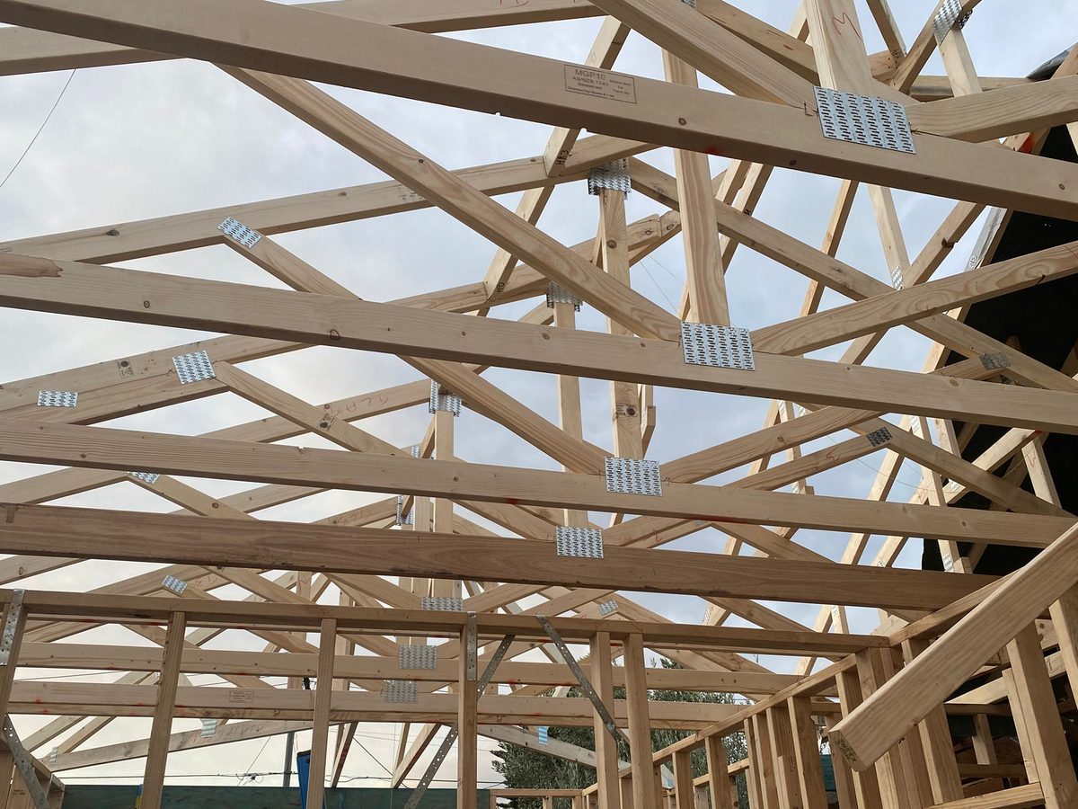 Prefabricated roof trusses fixed over the new extension, seen from below with gang-nail plates at each node, Melbourne’s south-east.